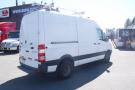 A white 2012 Mercedes-Benz Sprinter van with a high roof and ladder rack on top is shown from the rear left side