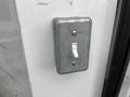 A metal toggle switch mounted on a surface with visible screws and a clean design