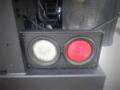 A close-up of a 2008 Ford F-550's rear light assembly featuring a round white light and a round red light