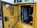 Close-up of the engine compartment of a 2024 Caterpillar 306 featuring a radiator and various mechanical components