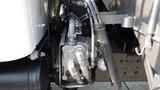 Close-up of a hydraulic system with metal pipes and hoses connected to a pump on a 2003 International 5600i truck