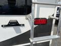 A close-up of the rear side of a 2013 Outdoor Wind River with a red tail light and a ladder attachment visible on the side