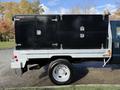 A 2008 Ford F-550 with a metal service body featuring two black storage compartments with silver handles mounted on a silver flatbed