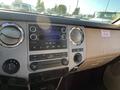 The interior dashboard of a 2014 Ford F-350 SD featuring a stereo system with buttons knobs and a screen