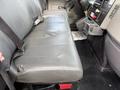 A gray leather bench seat with a seatbelt in an International 4300 truck's cab