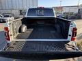 A 2023 RAM 3500 truck bed viewed from the rear showing a black rubber bed liner and storage compartments on either side