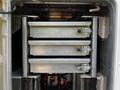 Three metal storage drawers stacked vertically inside a compartment of a 2016 Ford F-550