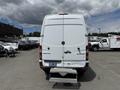 A white 2016 Mercedes-Benz Sprinter van with double rear doors and a metal step mounted at the back