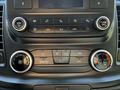 Dashboard controls of a 2023 Ford Transit featuring air conditioning dials and media buttons