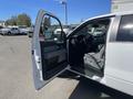 A 2012 Ford F-150 with an open driver side door showcasing the interior including the steering wheel and front seats