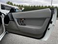 Door panel of a 1992 Chevrolet Corvette featuring gray upholstery with a control panel and handle