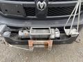 A close-up of a 2016 RAM 1500's winch mounted on the front bumper with a steel cable and safety mechanisms visible