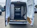 Interior view of a 2013 Ford Transit Connect with the rear doors open showing metallic shelves and a bare cargo space