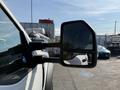 A close-up view of the side mirror of a white 2022 Ford F600 showcasing its design and reflective surface