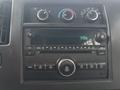 The dashboard of a 2020 Chevrolet Express featuring radio controls knobs display and buttons for media and climate settings