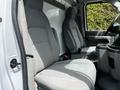 Interior of a 2018 Ford Econoline showing two gray front seats with a central console and space for storage