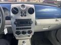 Interior dashboard of a 2007 Chrysler PT Cruiser with controls for the radio and climate system in a silver and blue design