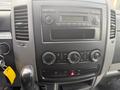 Dashboard of a 2009 Dodge Sprinter Van featuring a radio control panel climate control knobs and a gear shift with accessory key attached
