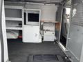 Interior of a 2009 Ford Econoline van featuring shelves a monitor and storage compartments designed for work utility