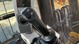 Close-up of the control joystick of a 2018 Caterpillar 326F L Excavator with buttons and textured grip