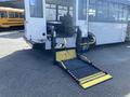 A 2017 Chevrolet Express with a deployed wheelchair lift at the back featuring a textured ramp and yellow safety markings