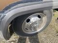 Close-up of a silver wheel with a five-bolt pattern and black tire tread of a 1987 Chevrolet Fleetwood Pace Arrow motorhome
