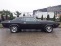 1974 Dodge Challenger in black with a sleek design featuring sporty lines and chrome accents standing sideways on a wet surface