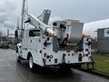 A white 2013 International DuraStar utility truck with a mounted aerial lift and bucket in the rear, featuring several safety lights and controls on the back