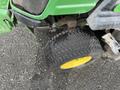 A close-up of a tire from a 2014 John Deere 1585 Terrain Cut lawn mower showing a textured tread and yellow rim