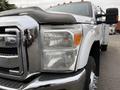 A 2013 Ford F-350 SD with a shiny chrome grille and reflecting headlights showcasing a silver and black color scheme