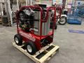 A red and silver 2024 Magnum 4000 Hot Water Pressure Washer with two large wheels and a sturdy frame positioned on a wooden pallet