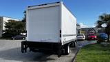 A white 2016 Isuzu NPR box truck parked with a closed rear door and no visible markings on the exterior