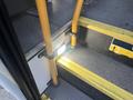 A 2017 Chevrolet Express with yellow handrails and illuminated step area on the entrance stairs