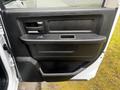 A close-up view of the driver's side door panel of a 2022 RAM 1500 Classic featuring a black handle speaker and armrest