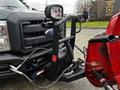 A 2012 Ford F-550 with a front-mounted plow attachment and mounted headlights