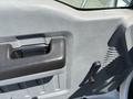Interior door panel of a 2015 Ford F-750 showing a door handle and window control with textured surfaces