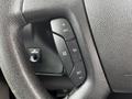 Close-up of a steering wheel with buttons for cruise control settings including resume, set, and a light symbol