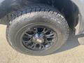 The image shows a black wheel and tire of a 2021 RAM 1500 featuring a rugged tire tread and a bold wheel design