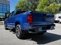 A blue 2021 Chevrolet Colorado pickup truck is shown from the rear right angle with visible branding and a sleek design