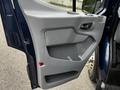 The interior door panel of a 2017 Ford Transit 350 featuring a gray plastic design with a handle and storage compartment