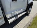 A 2023 Ford F-550 with a polished body and diamond plate running boards on the side