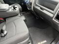 Interior view of a 2019 RAM 1500 Classic featuring a black cloth seat console with storage and close-up of floor with RAM branding and dashboard controls visible