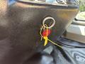 Close-up of a ignition switch in a 2017 Chevrolet Express with a red button labeled FIRE and a yellow tag attached to a keyring