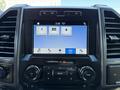 Dashboard display of a 2018 Ford F-150 with a touchscreen interface showing various app options and controls for audio and phone settings
