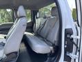 Interior view of a 2016 Ford F-150 showing the rear seats with light gray upholstery and seatbelts attached