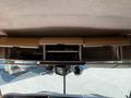 The interior of a 2000 Ford Motorhome featuring a dashboard with a console that includes storage compartments and electronic devices