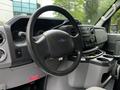 Interior view of a 2013 Ford Econoline showing the steering wheel dashboard and center console with controls and storage compartments