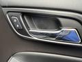 Close-up of the interior door handle of a 2016 Chevrolet Tahoe showing the lock and unlock buttons in a sleek design
