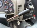 Close-up of the gear shift lever in a 2016 International 7600 truck's cabin showing a worn handle and adjacent dashboard gauges