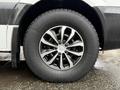 Close-up of a wheel of a 2016 Mercedes-Benz Sprinter featuring a silver multi-spoke rim and a black tire with visible water droplets on the surface